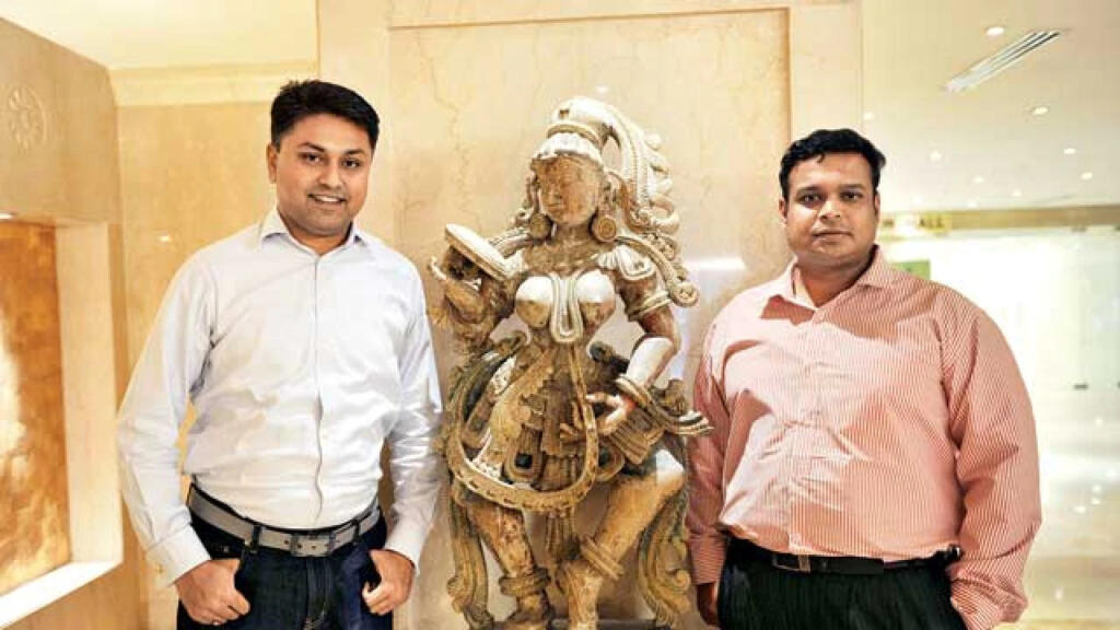 विजय कुमार प्राचीन मूर्ति के साथ खड़े है