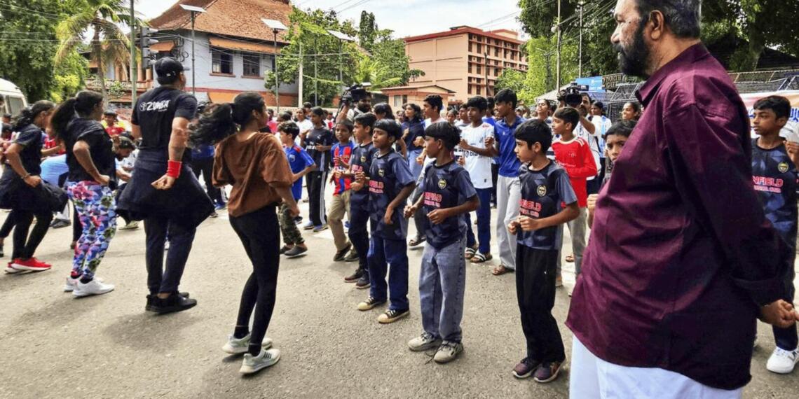 छात्रों का जुम्बा देखते केरल के शिक्षा मंत्री वी. शिवनकुट्टी