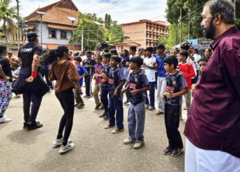 छात्रों का जुम्बा देखते केरल के शिक्षा मंत्री वी. शिवनकुट्टी