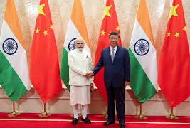 प्रधानमंत्री मोदी और राष्ट्रपति जिनपिंग हाथ मिलाते हुए